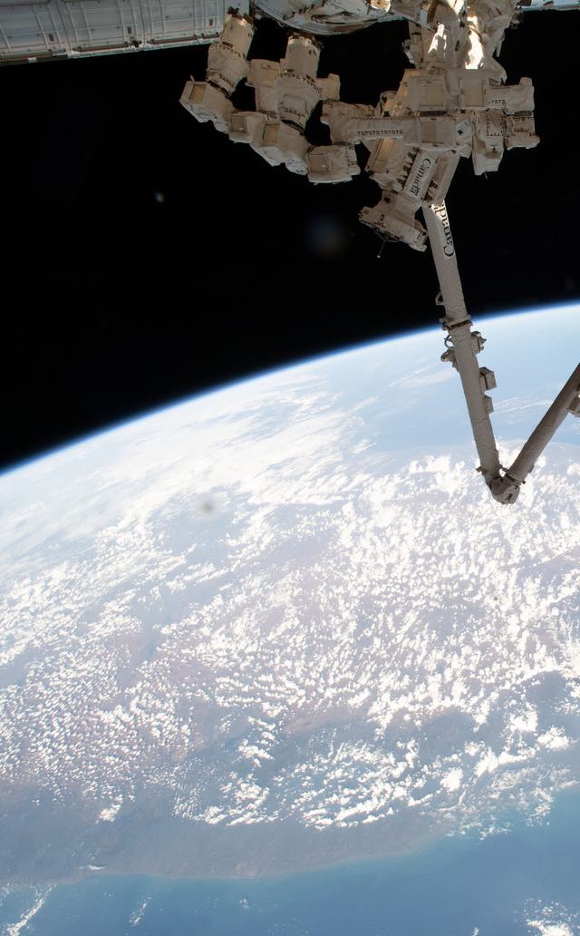 Canadarm2 and Dextre robotic arms above Earth
